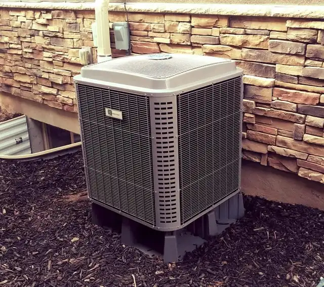 A Heavenly Heating and Cooling technician servicing a high-efficiency heat pump